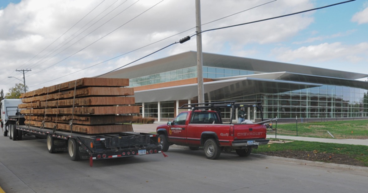Semi loaded with the laminated wood sections heads down 10th avenue, passing the Bear Center