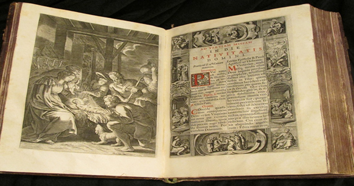 A large book opened to an engraving of the nativity