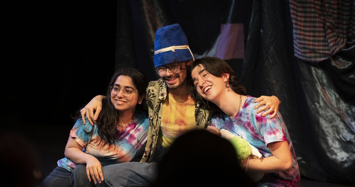 A young man and two women Neverlanders onstage