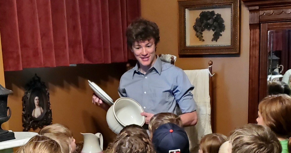 Evan Albaugh '25 leads a group of students on a tour of Hoyt Sherman Place in Des Moines.