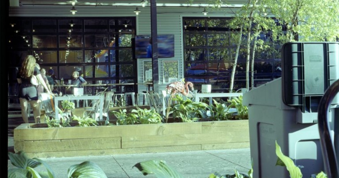 An outdoor shot peeking into a glass window of a cafe. The image is tinted green.