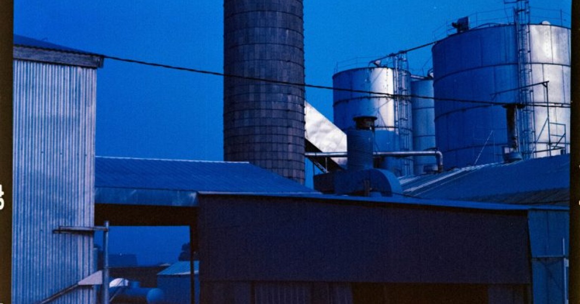 A super dark blue image full of factory buildings.