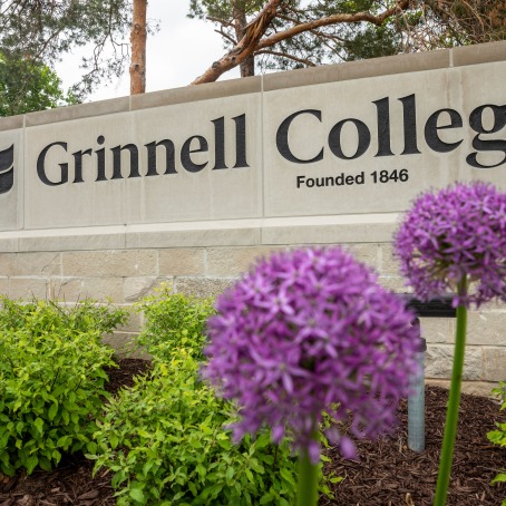 Grinnell College gateway sign with purple flowers