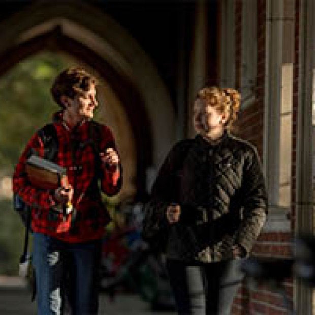 two students walking in the loggia