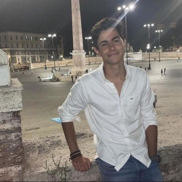 Mikel de Julian smiling and standing in front of city square at night