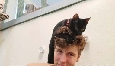 student with cat on his head 