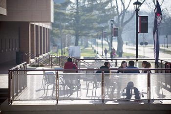 Students studying at outdoor tables.