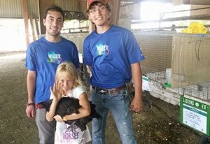 Nick Hunter with fellow intern Lance Henrichs pose with a new friend and her prize chicken.