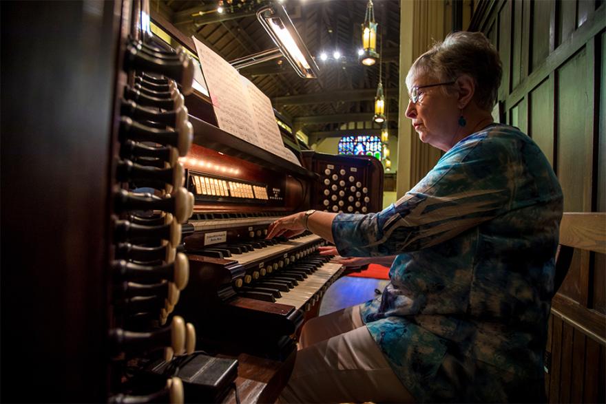 Linda Bryant sitting at the organ in Herrick Chapel