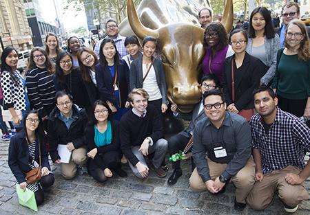 Jarren Santos and other students on a fall break tour to New York City pose in front of the Wall Street bull. 