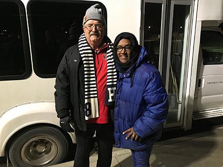 Will Freeman and Kesho Scott stand in front of a bus