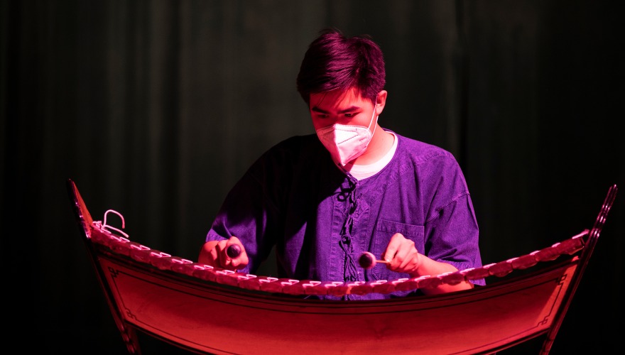 A student performs on a musical instrument