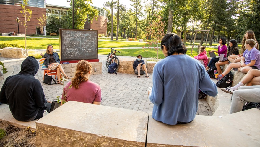 students sitting in Kington Plaza for class