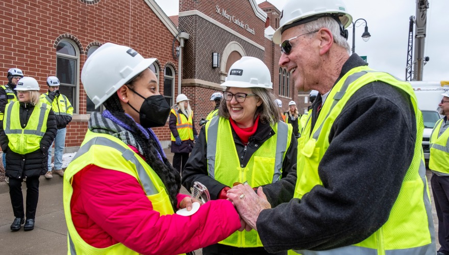 Feven A. Getachew '24., Grinnell College President Anne F. Harris, and Grinnell Mayor Dan Agnew gather for the Renfrow Hall Topping Off Ceremony.  