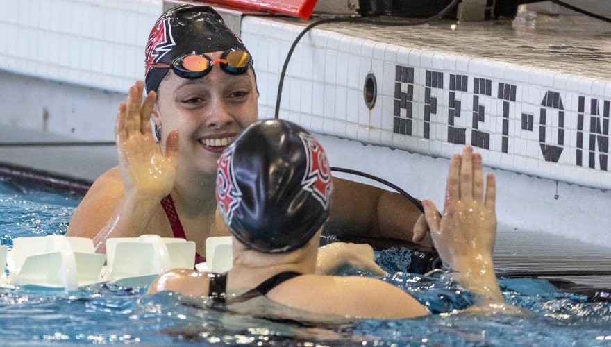 two swimmers smiling and high five