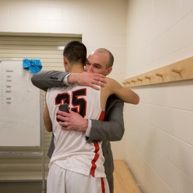 David Arseneault Jr. hugging a Grinnell College basketball player.