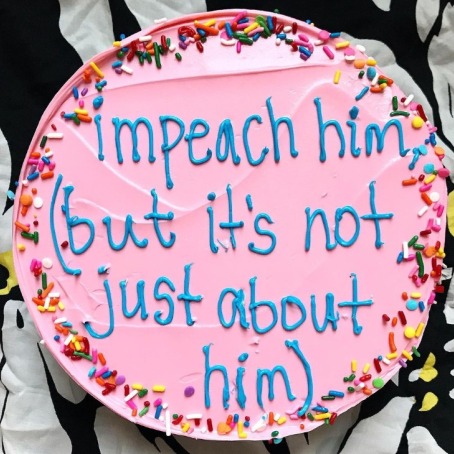 A pink cake with sprinkles around the edge, which reads, "Impeach him (but it's not just about him)."