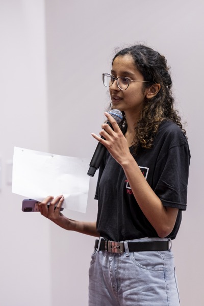 Jivyaa Vaidya speaks using a microphone. 