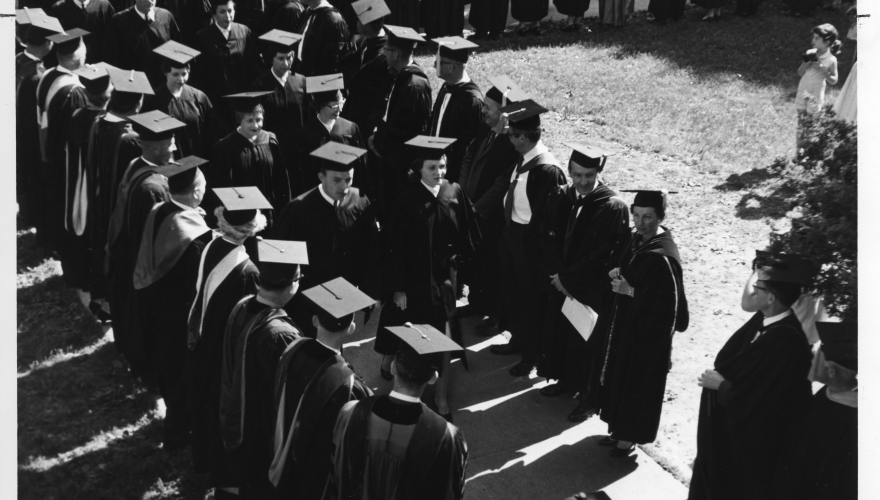 Graduating seniors walk through faculty ranks during commencement, June 4, 1961. Linda Newman Woito, class of 1961, is front of the line on the right. 