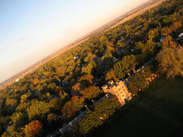 Image of north campus shot at an angle to the horizon. Trees are visible before and behind the halls, beginning to turn fall colors. Fields are visible to the west. 