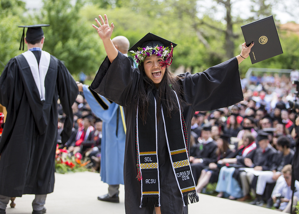 Graduate with diploma with mortarboard wreathed in flowers