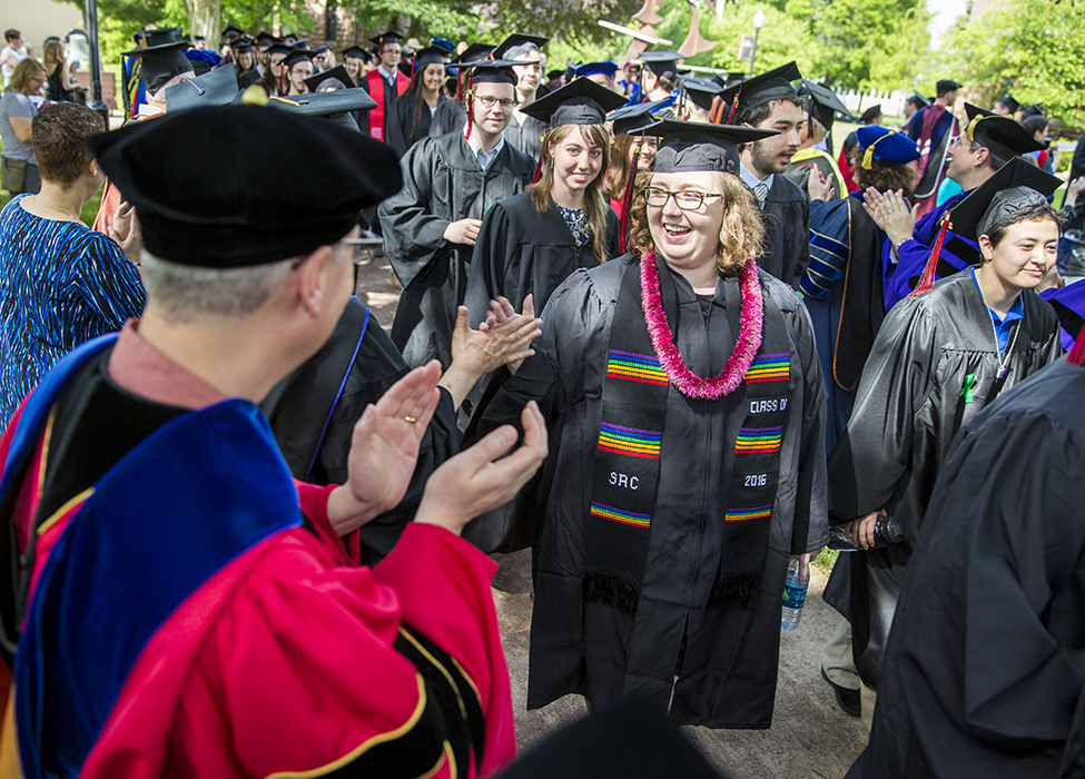 Students receive congratulations from professors lining the processional path.