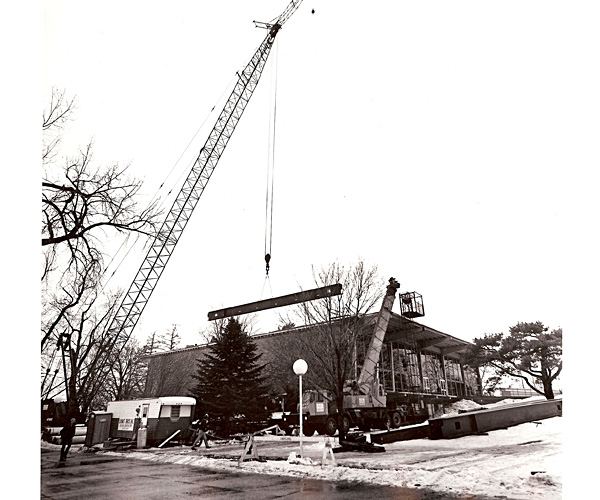 crane carrying a large beam to the top of Burling Library