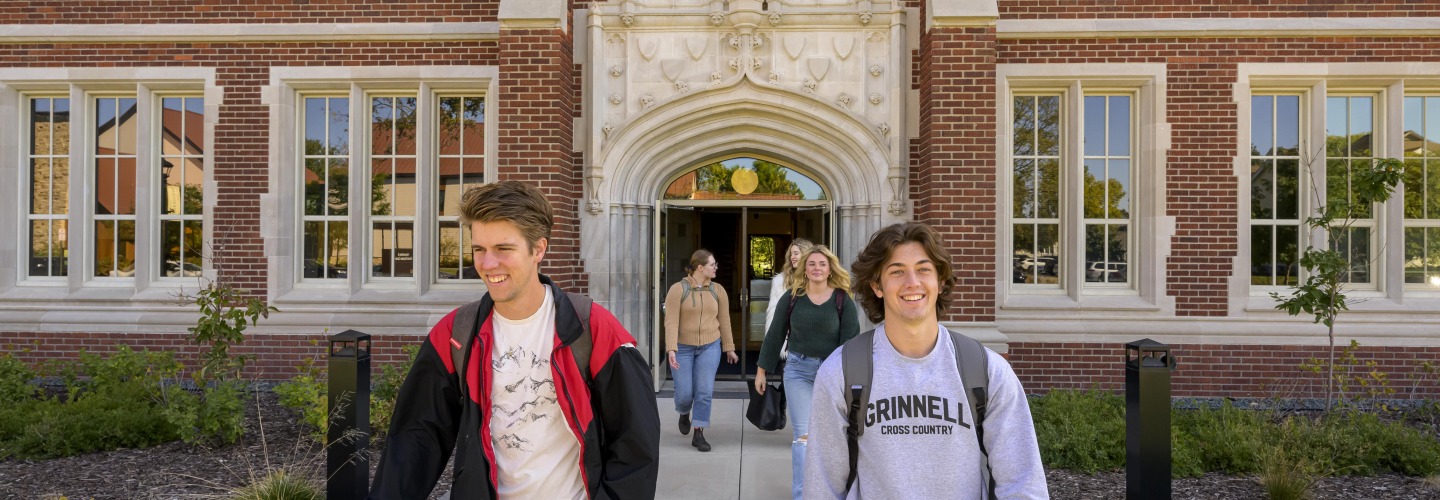 Happy students walk out of a building