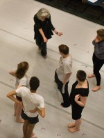 Celeste Miller, Professor of Dance, works with attentive ensemble members during rehearsal