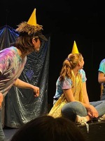 The Neverland Players perform in tie-dye shirts and party hats