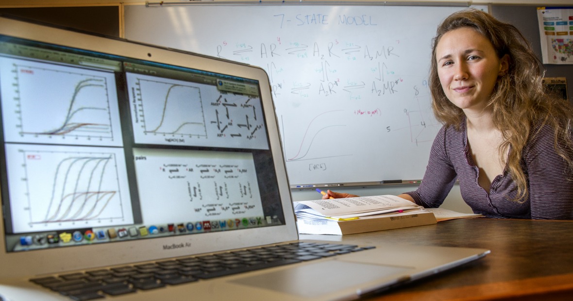 Josie Bircher next to computer with models of data