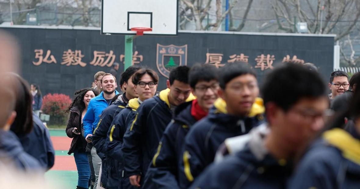 Grinnellians' varied coats stand out from behind a line of Chinese runners dressed in black and yellow coats.