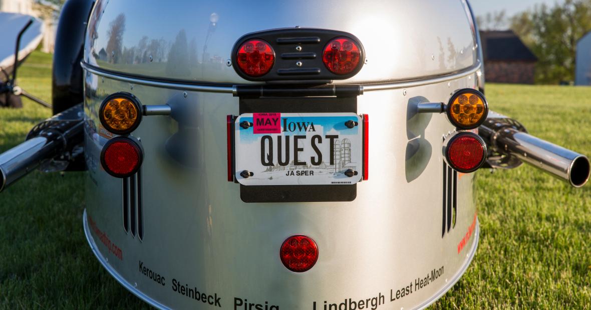 Rear view of Will Freeman's three-wheel vehicle with license plate and names of famous writers