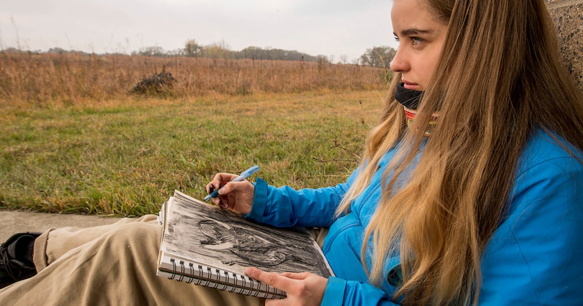 Student sits at CERA drawing a bison