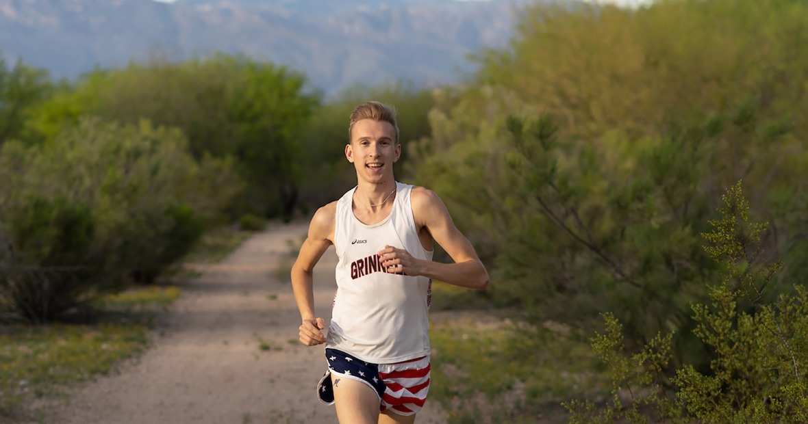 Adam Dalton ’16 running on a remote road in the mountains wearing Grinnell shirt