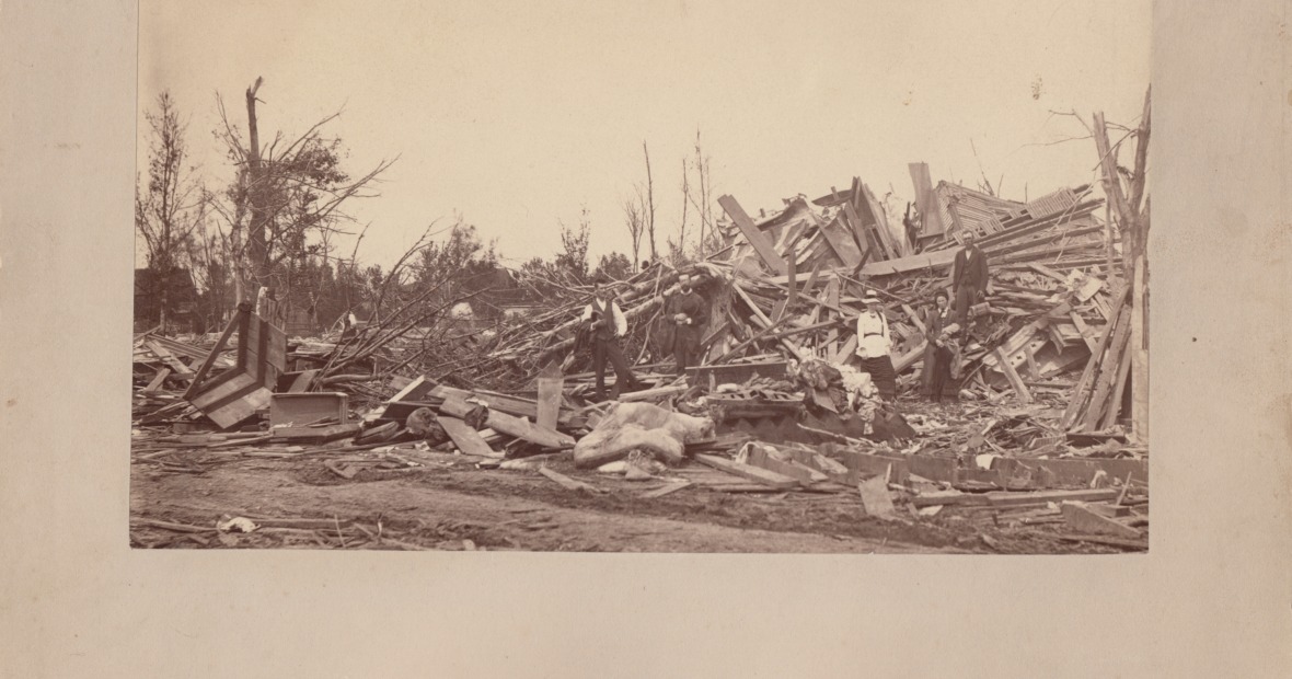 men and women survey the ruins of the cyclone