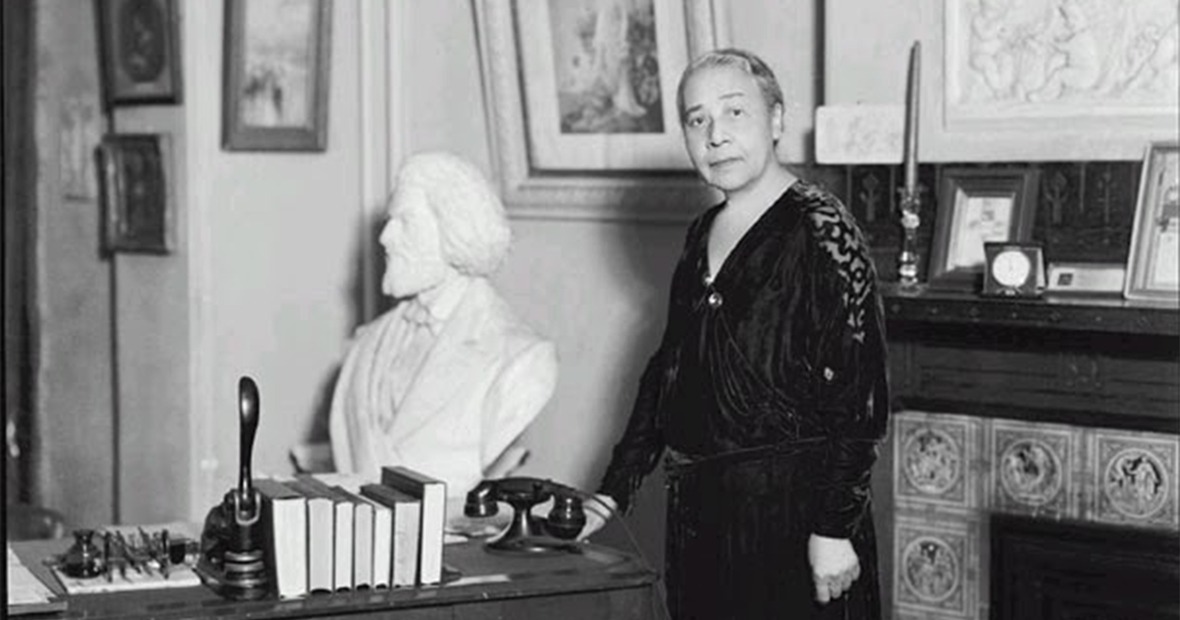 Anna Julia Cooper in a parlor with a bust of Frederick Douglass