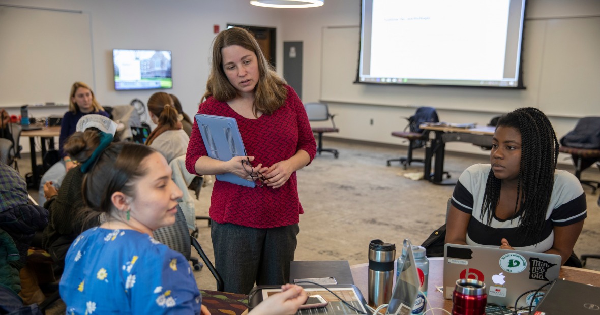 Professor Tammy Nyden (center) listens to two students during class