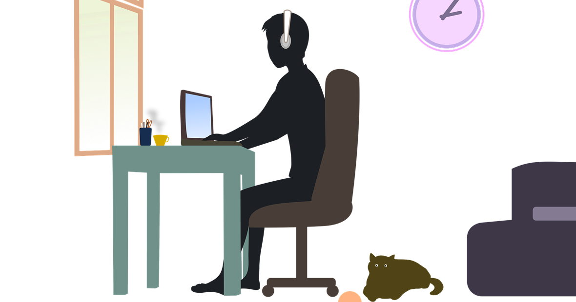 Student sitting at desk w/cat on floor