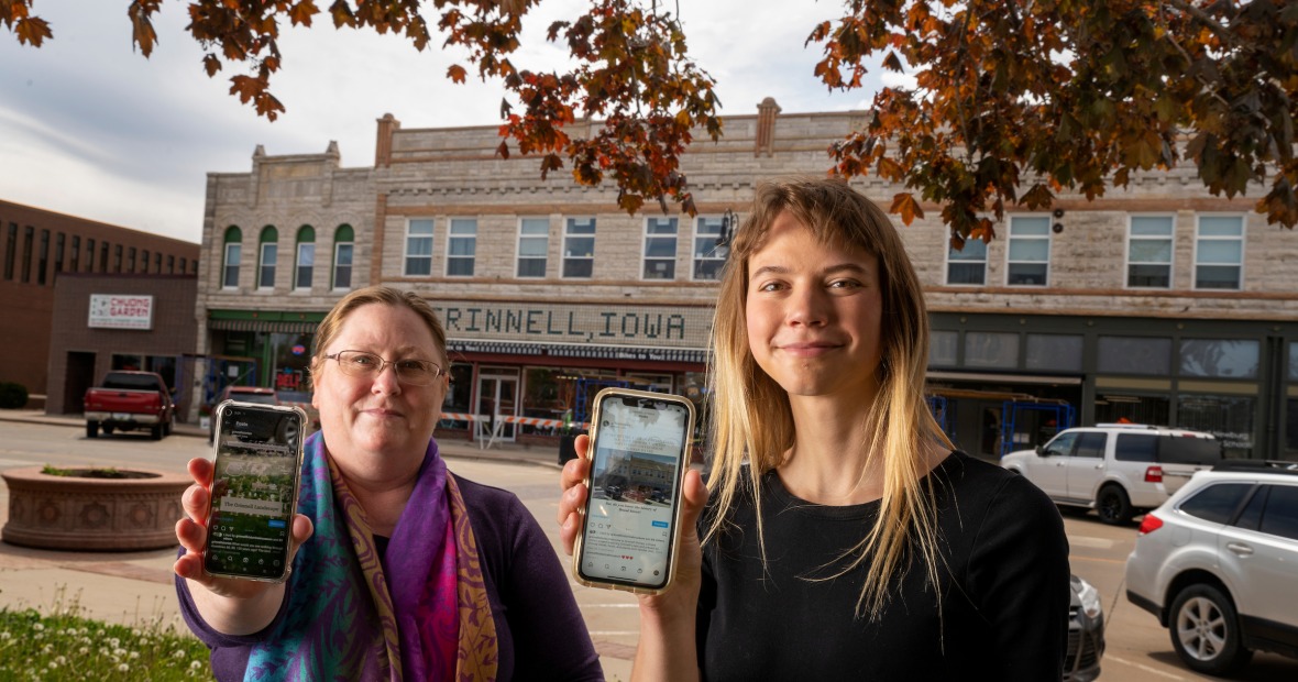 Monique McLay Shore ’90 and Allison Cottrell ’21 in downtown Grinnell holding up their smart phones