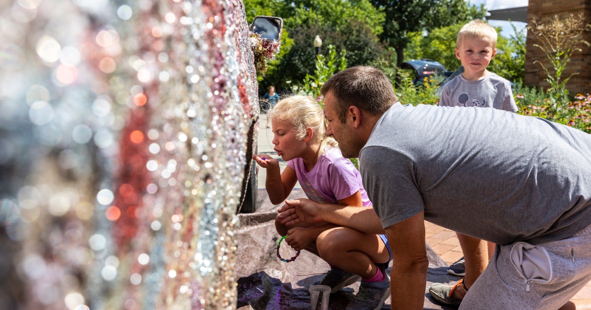 A child and an adult add their artistic touches to the glitter truck.