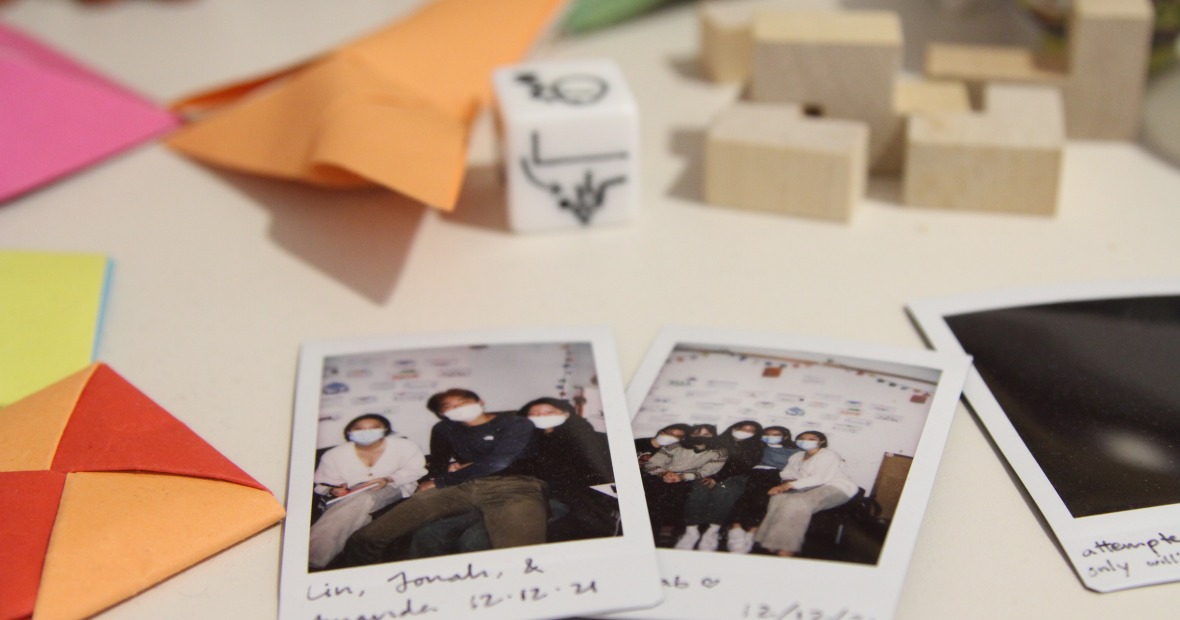 Two polaroid images surrounded by origami pieces