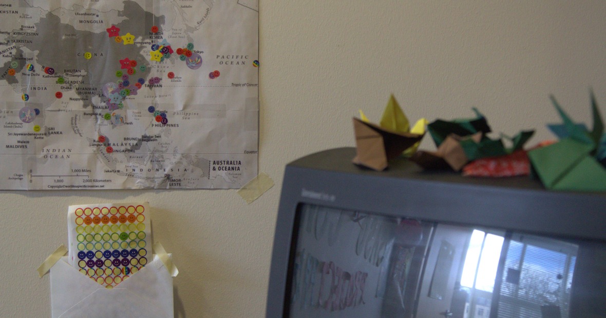 A TV with origami pieces next to a map with stickers below to place on the map