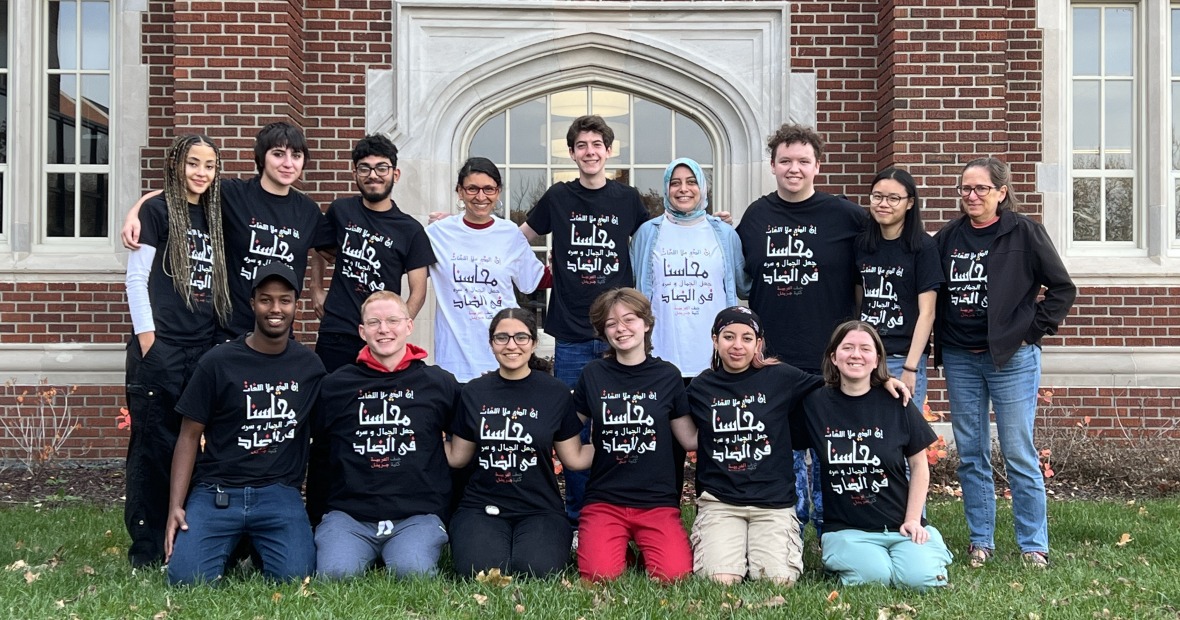 Arabic 101 students standing as a group showing off their class t-shirts