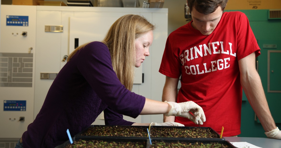 Two students in a biology lab, one of who is wearing a Grinnell College t-shirt