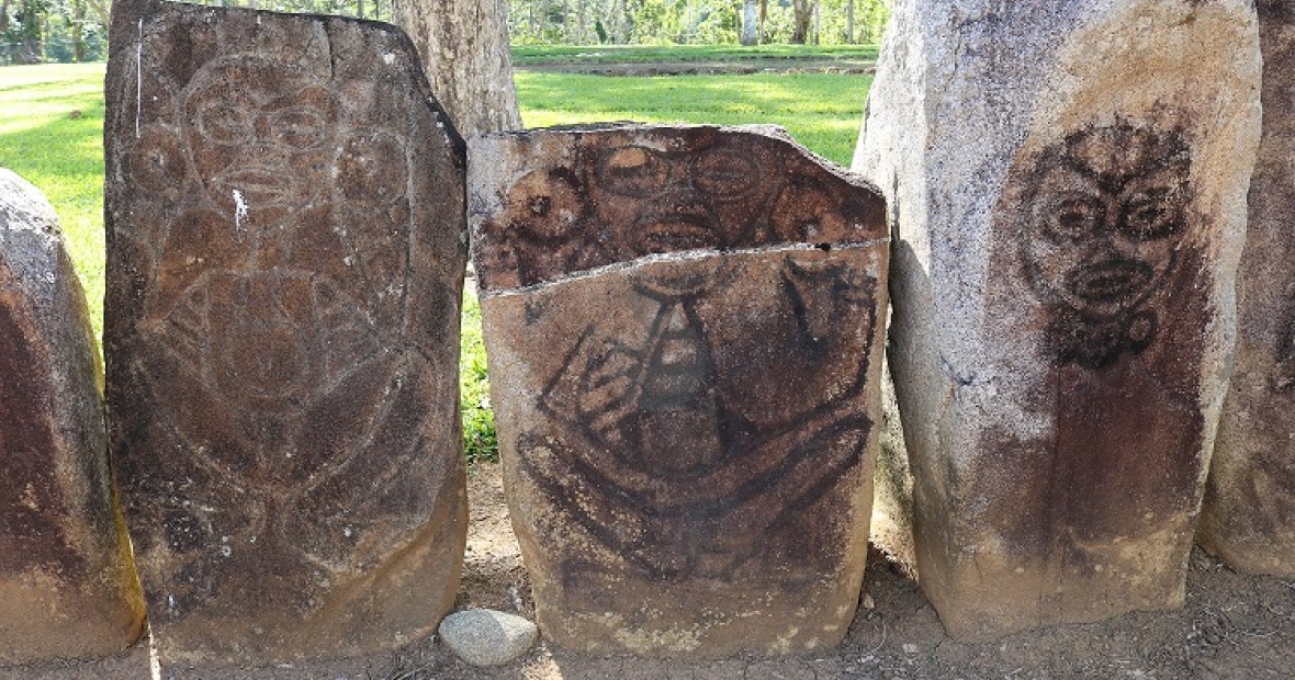 four weathered upright stones with petroglyphs of human figures