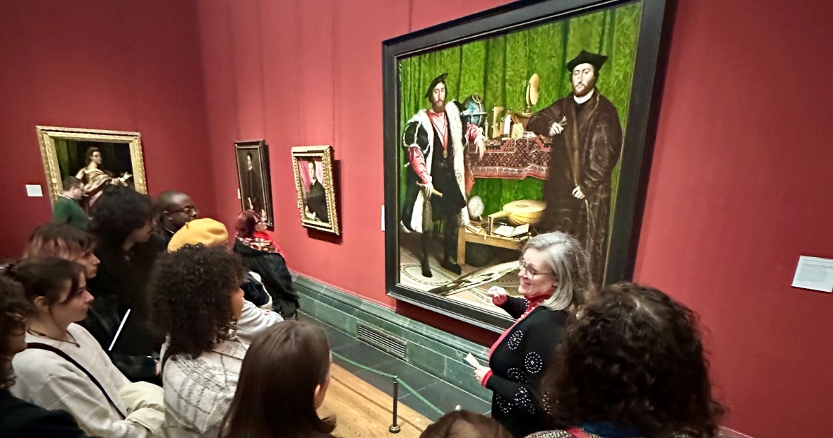 President Harris leads a talk at the National Gallery for GIL students. The group stands in front of The Ambassadors by Hans Holbein the Younger