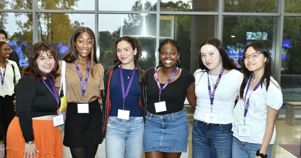 Six students standing in a row with their arms around each other.