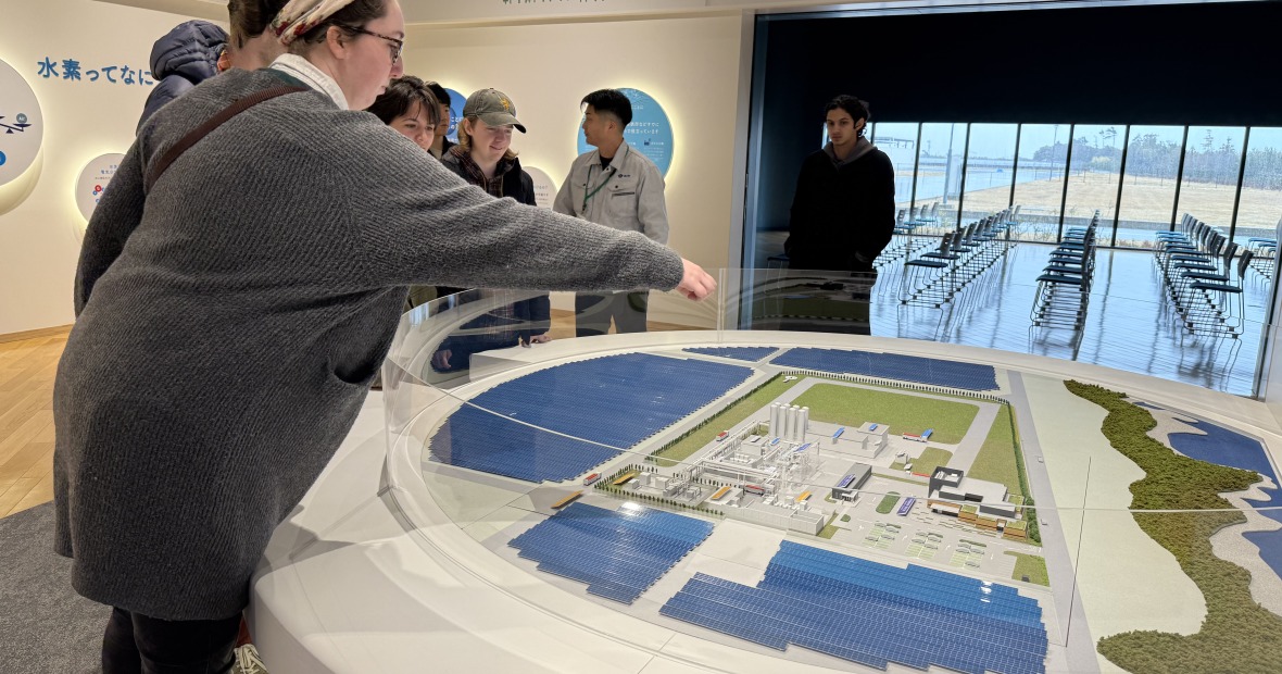 Emily Perry points at hydrogen plant model