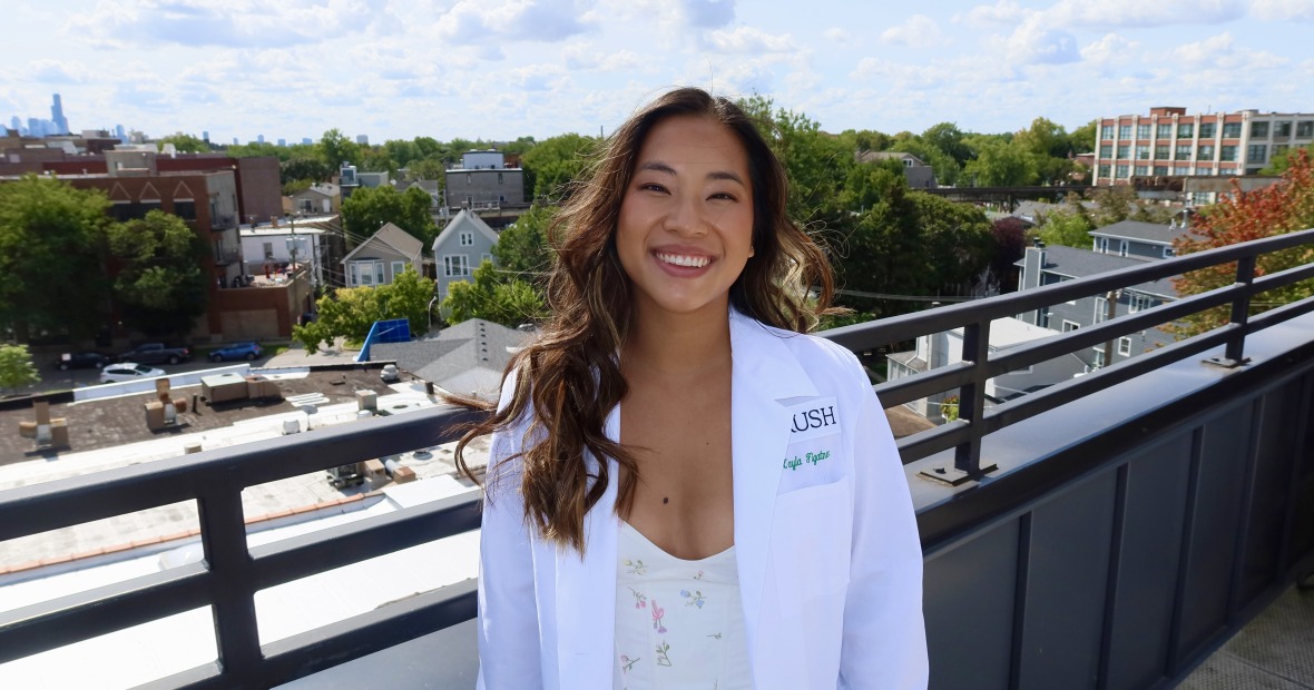Photo of Kayla Figatner in a white doctor's coat on the roof of a building